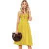 Yellow bow tie suspender maxi dress with front buttons worn by woman holding a black woven handbag